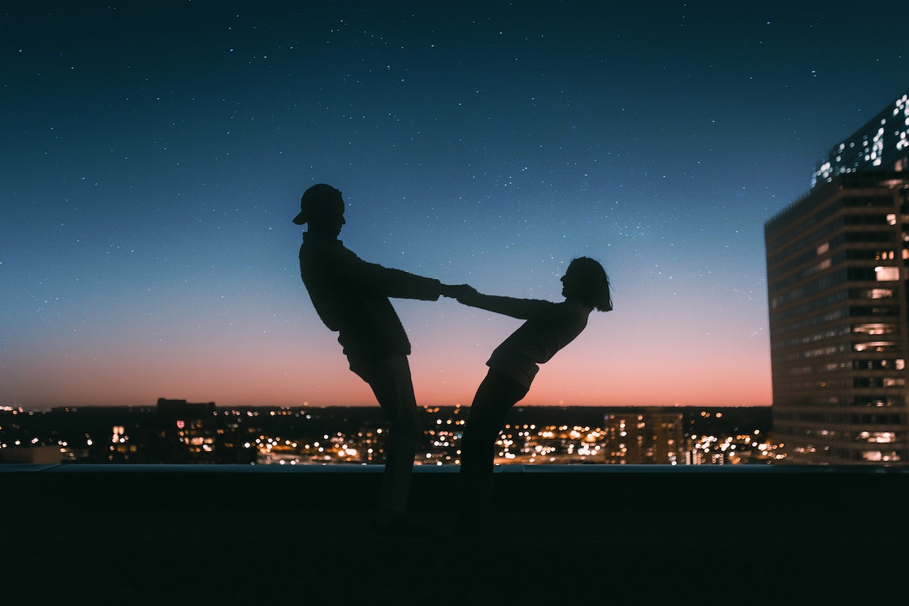 coppia che si tiene per mano durante il tramonto