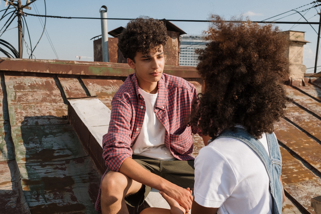 coppia di adolescenti seduta sul tetto